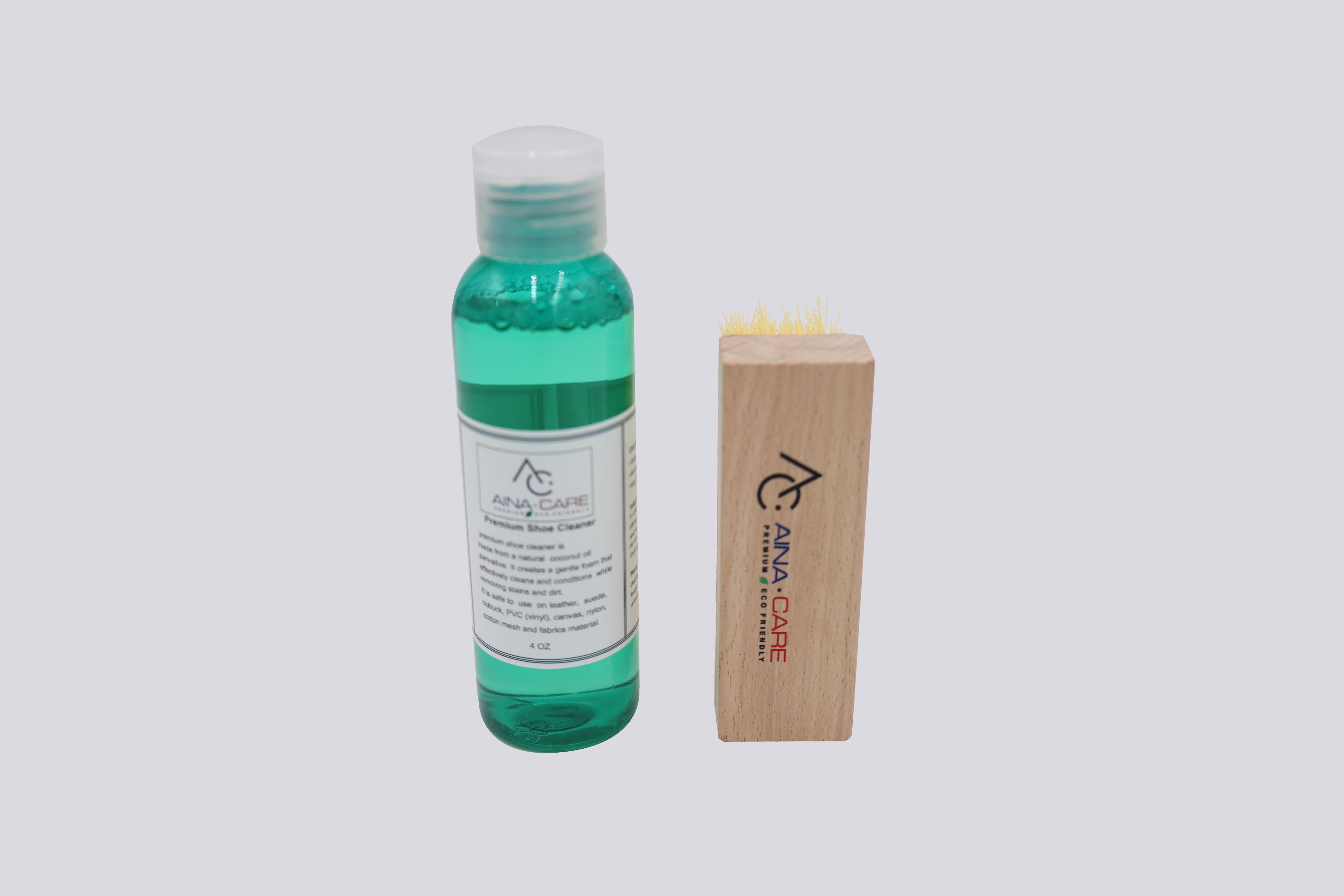A bottle of Premium Shoe Cleaner and a hand brush from AinaCare.