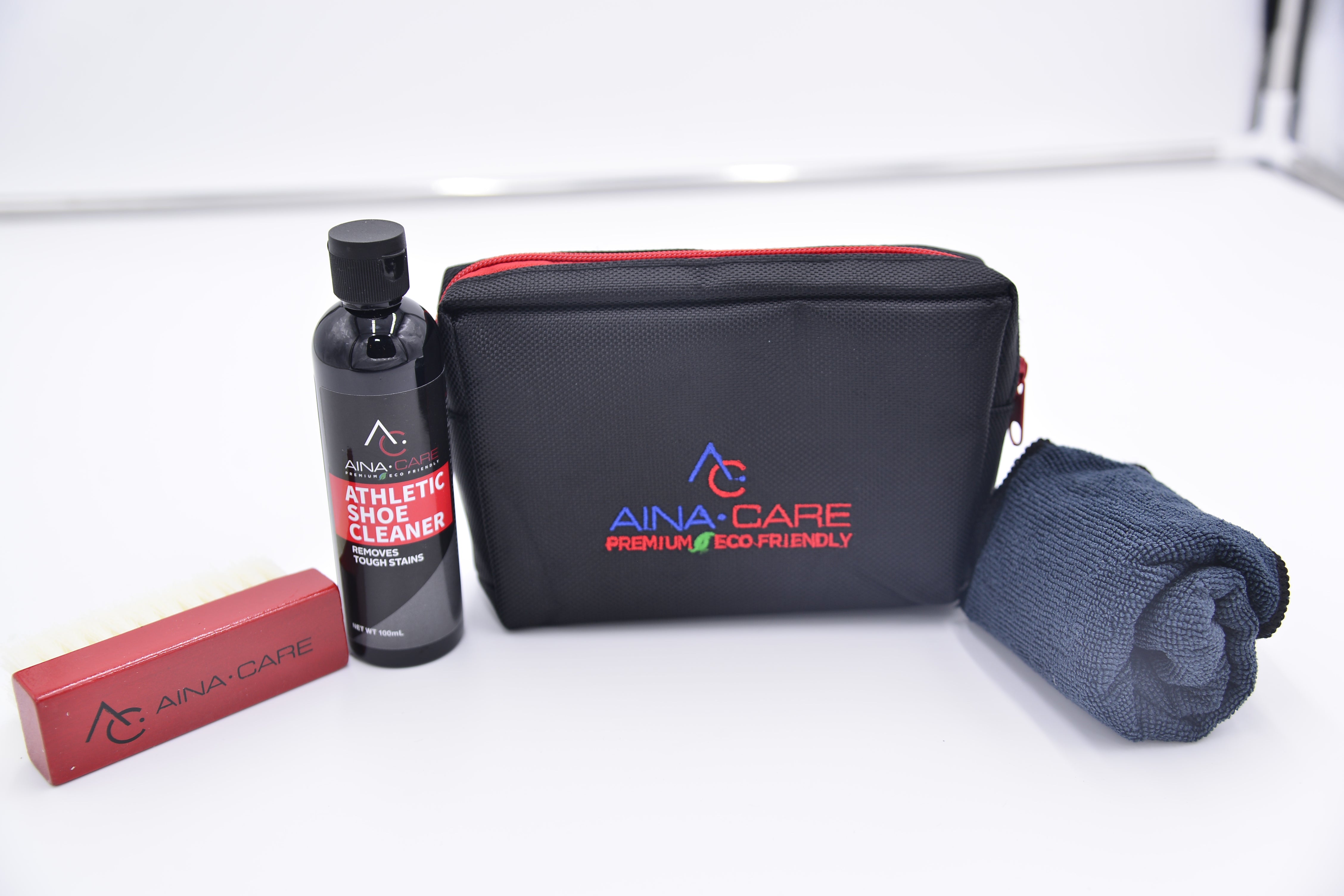 Everything in the Silver Shoe Care laid out on a table. Products include Athletic Shoe Cleaner, microfiber cloth, soft brush, and black travel bag.
